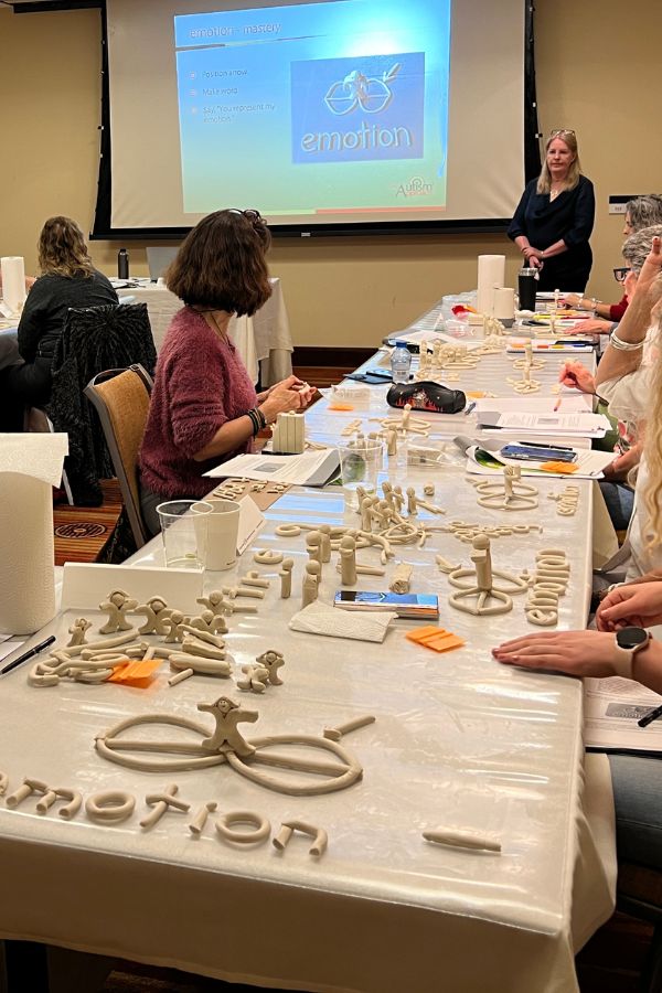 An in-person workshop, modelling the word emotion in clay, with their own interpretations of what that means