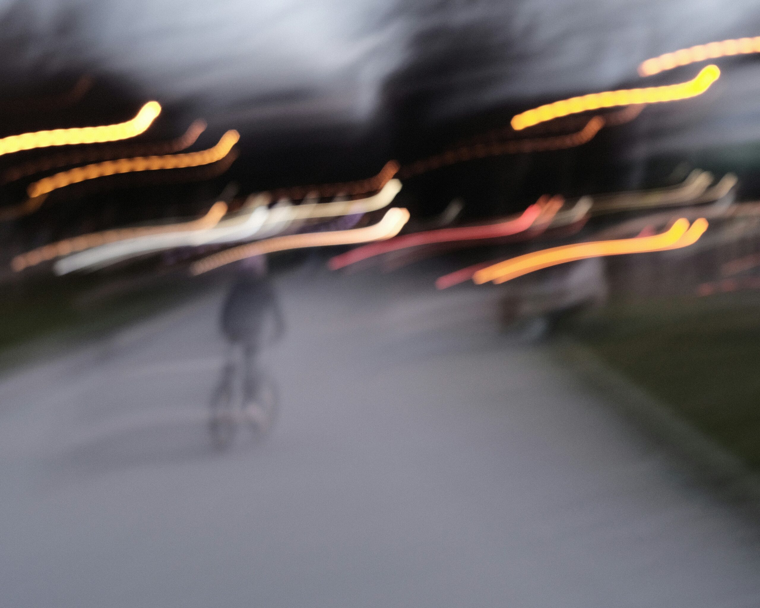 Blurry image of person in bike with street lights on