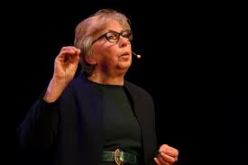 Sue Hall, with a headpiece microphone on, speaking at a live event